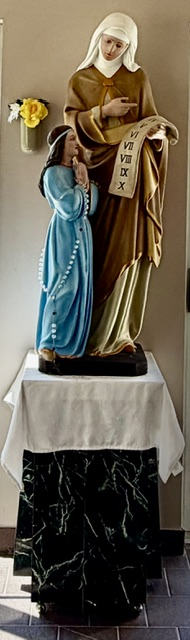 A statue of Saint Anne with the young Virgin Mary holding a scroll of the Ten Commandments.